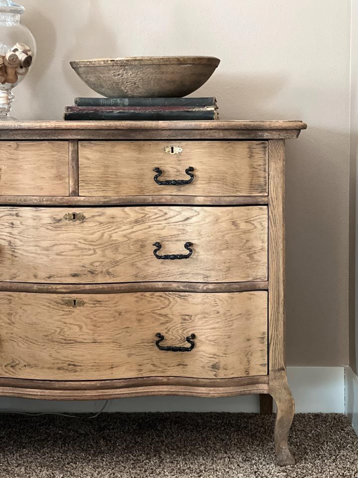 an old wooden dresser with a bowl on top