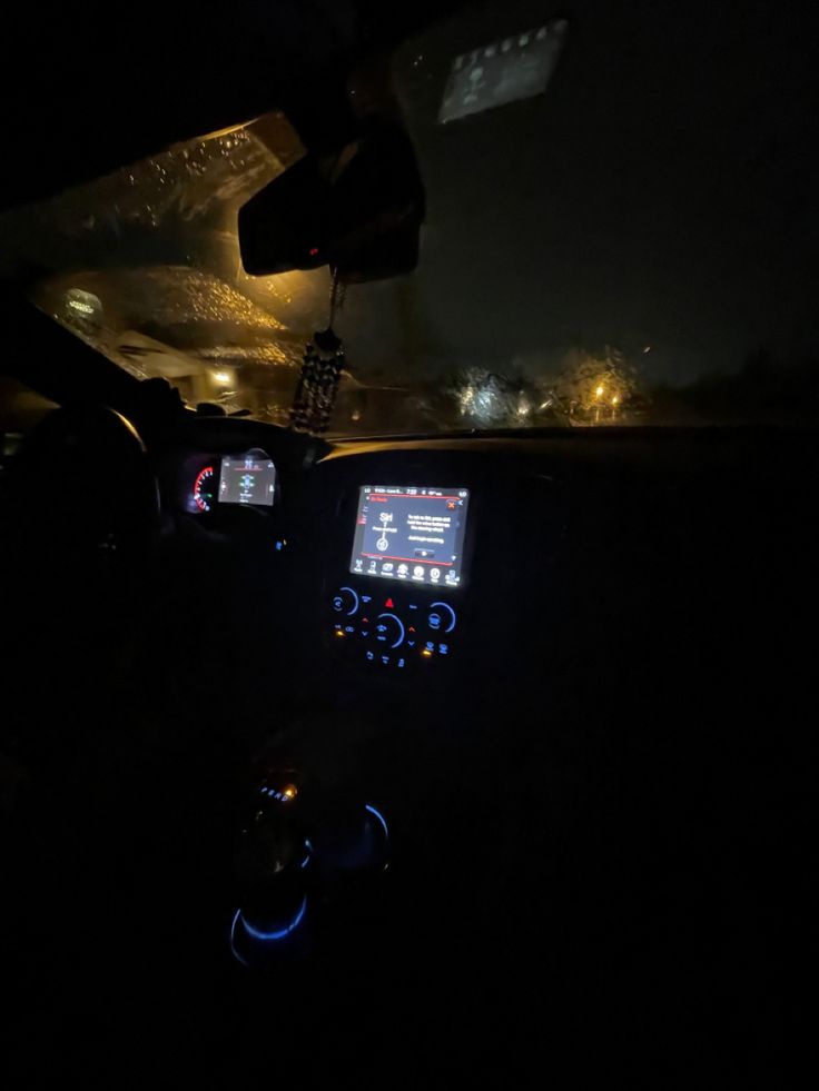 the interior of a car at night with dashboard lights on and electronic devices in the dash