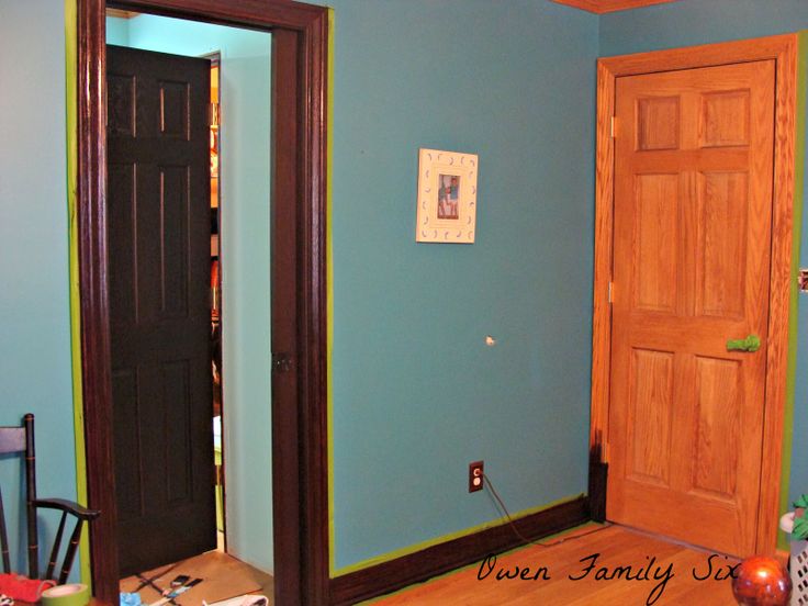 an empty room with blue walls and wooden doors