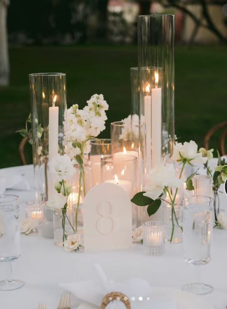 the table is set with candles, flowers and napkins for an elegant wedding reception