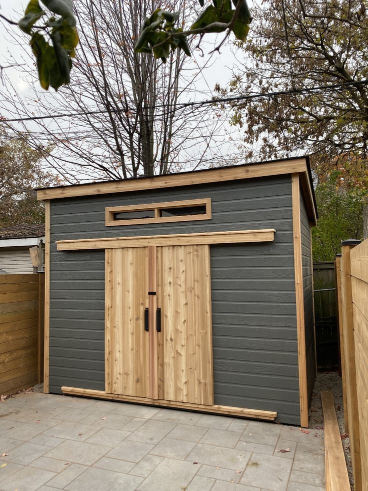 a small shed with wooden doors and windows