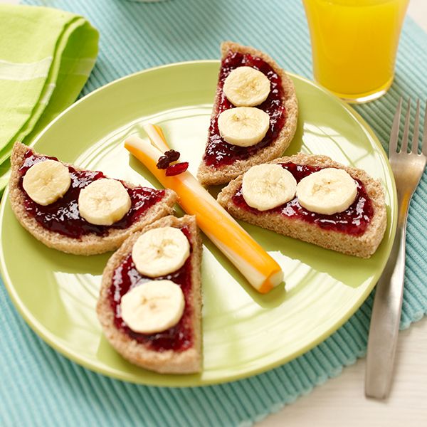 slices of bread with jam and banana slices on them sitting on a plate next to a glass of orange juice