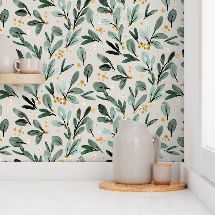 the wallpaper in this kitchen is painted with green leaves and gold dots on it