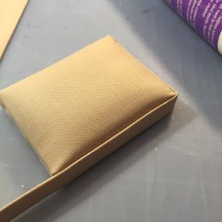 a piece of cardboard sitting on top of a table next to a roll of tape