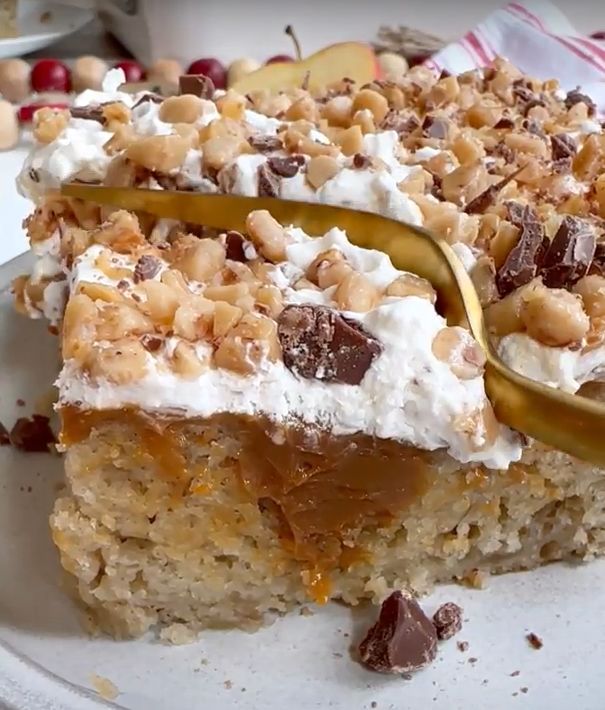 there is a piece of cake on the plate with a spoon in it and some nuts