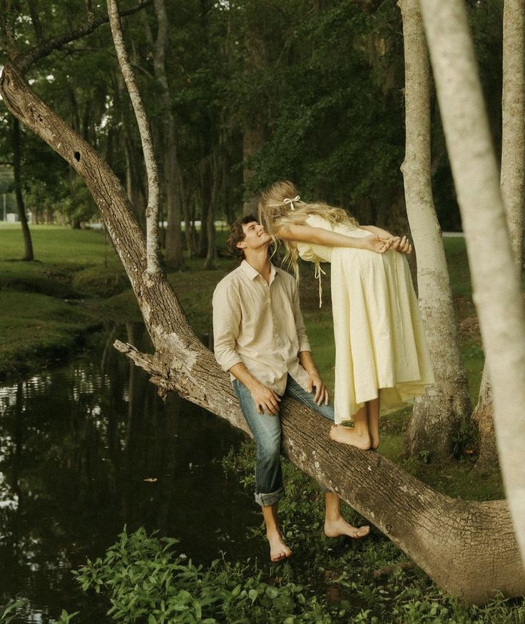 a man and woman are sitting on a tree branch