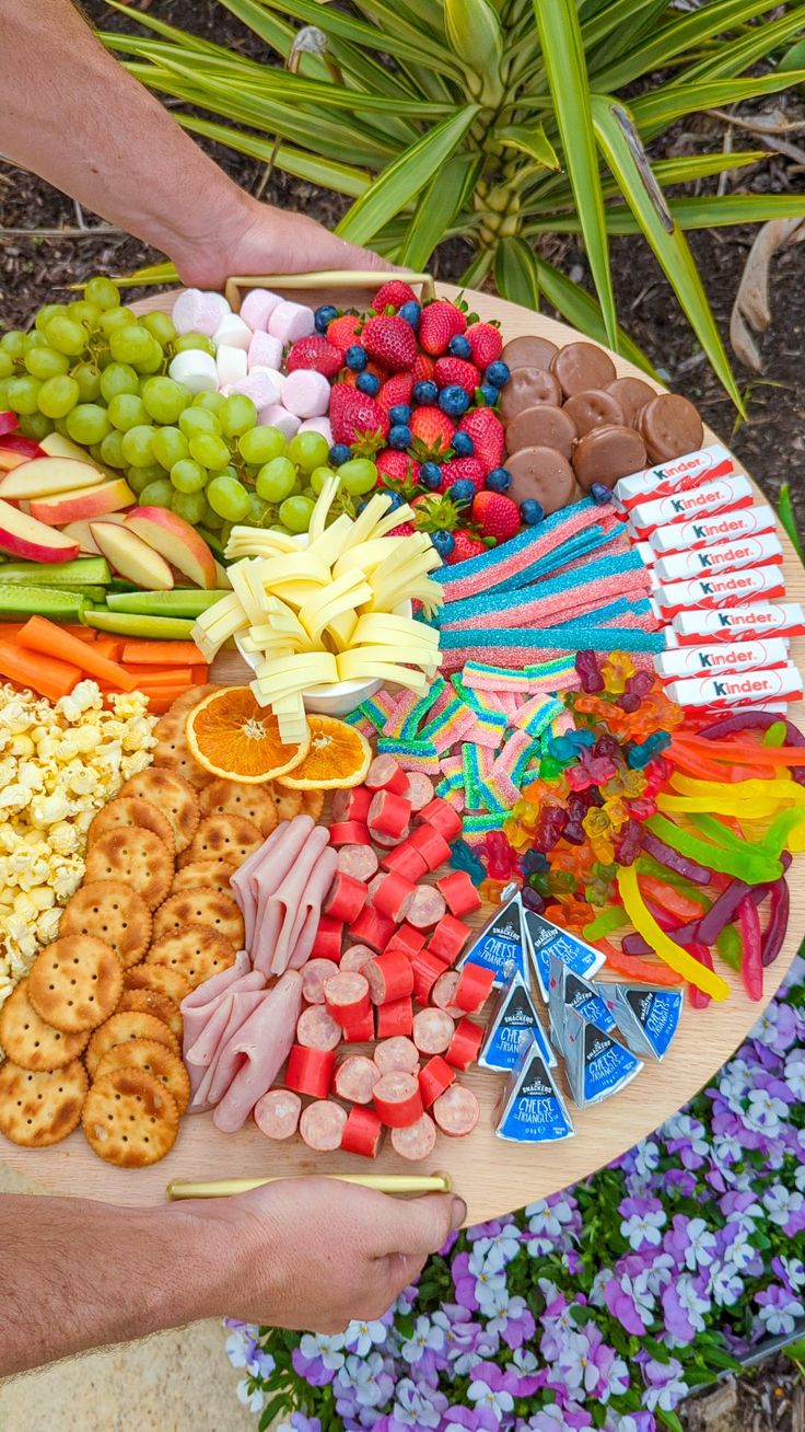 a platter filled with lots of different types of fruit and crackers on it