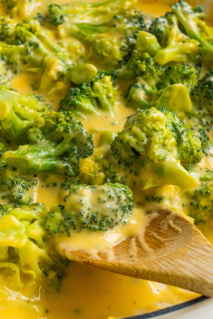 broccoli and cheese sauce in a pan with a wooden spoon