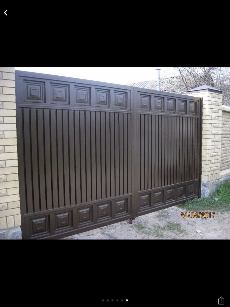 an image of a fence that is in the middle of some grass and brick walls