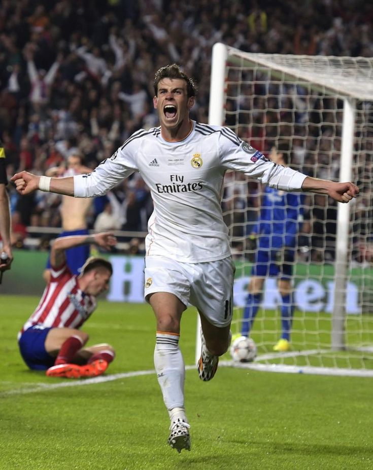 the soccer player is celebrating his goal in front of an excited crowd as he runs towards the goal