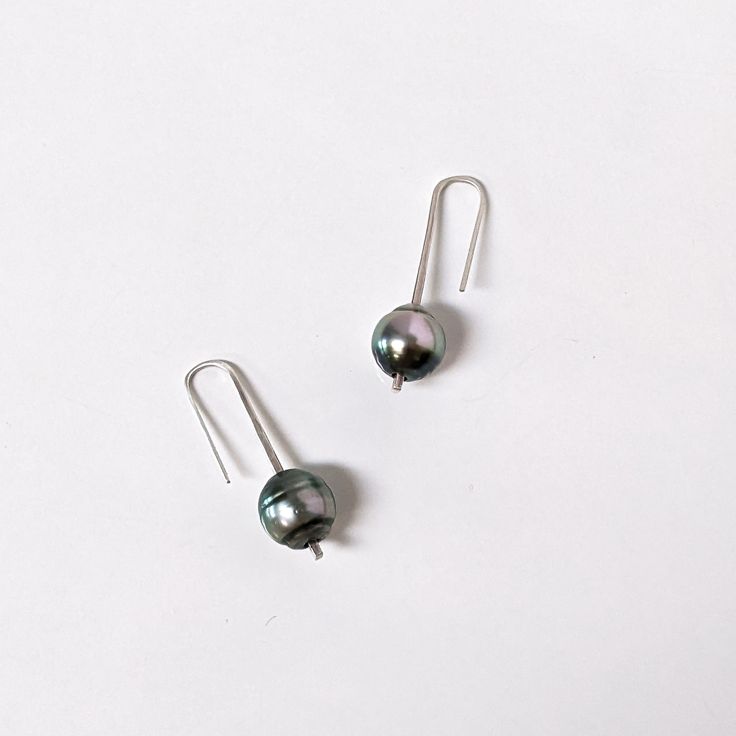 These sterling and Tahitian pearl drops are a your new everyday, minimalist elegant earring. Fabricated from one piece of tapered sterling silver that gives the pearl slight movement. They are light weight, go with everything, and make a lovely gift. Shipped in a branded fabric pouch and jewelry box. Dimensions: Tahitian Pearls: 9mm-11mm Short Drops: 1 5/16" / 33mm Medium Drops: 1.75" / 55mm Handcrafted by Rebecca Norman 2 medium + 2 long in stock and available to ship Silver Minimalist Pearl Earrings, Minimalist Hypoallergenic Pearl Earrings For Formal Events, Everyday Sterling Silver Drop Pearl Earrings, Modern Dangle Pearl Earrings For Everyday, Modern Pearl Earrings With Ear Wire As Gift, Formal Long Drop Pearl Earrings Minimalist Style, Modern Everyday Dangle Pearl Earrings, Modern Everyday Pearl Drop Earrings, Silver Minimalist Pearl Drop Earrings