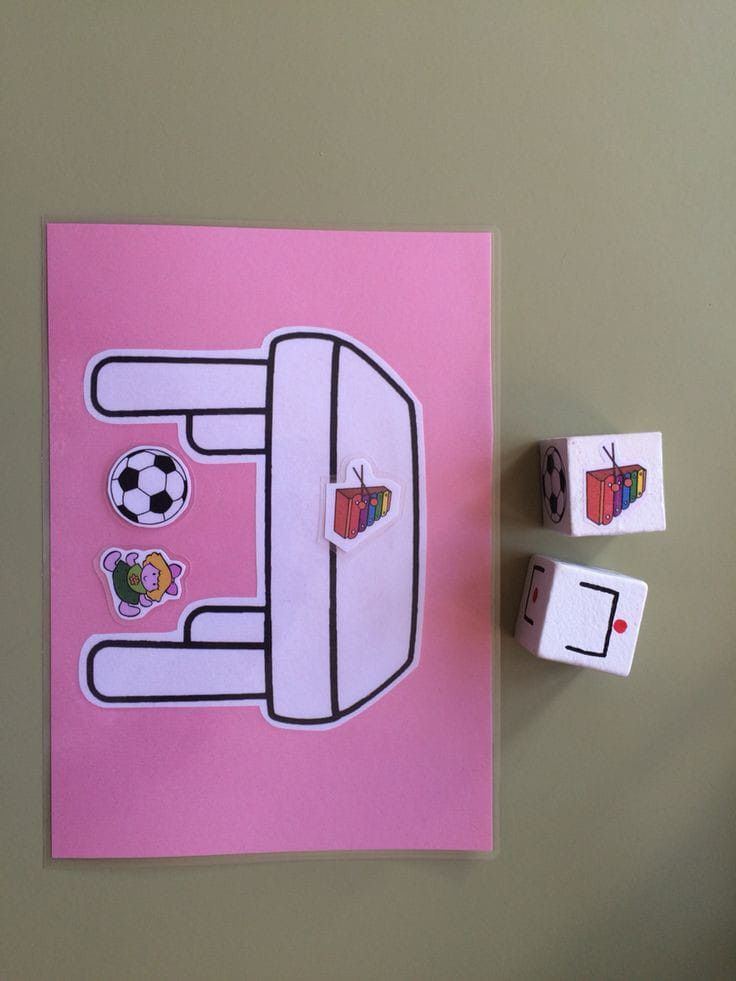 a pink card with the letter e on it and two dices next to it