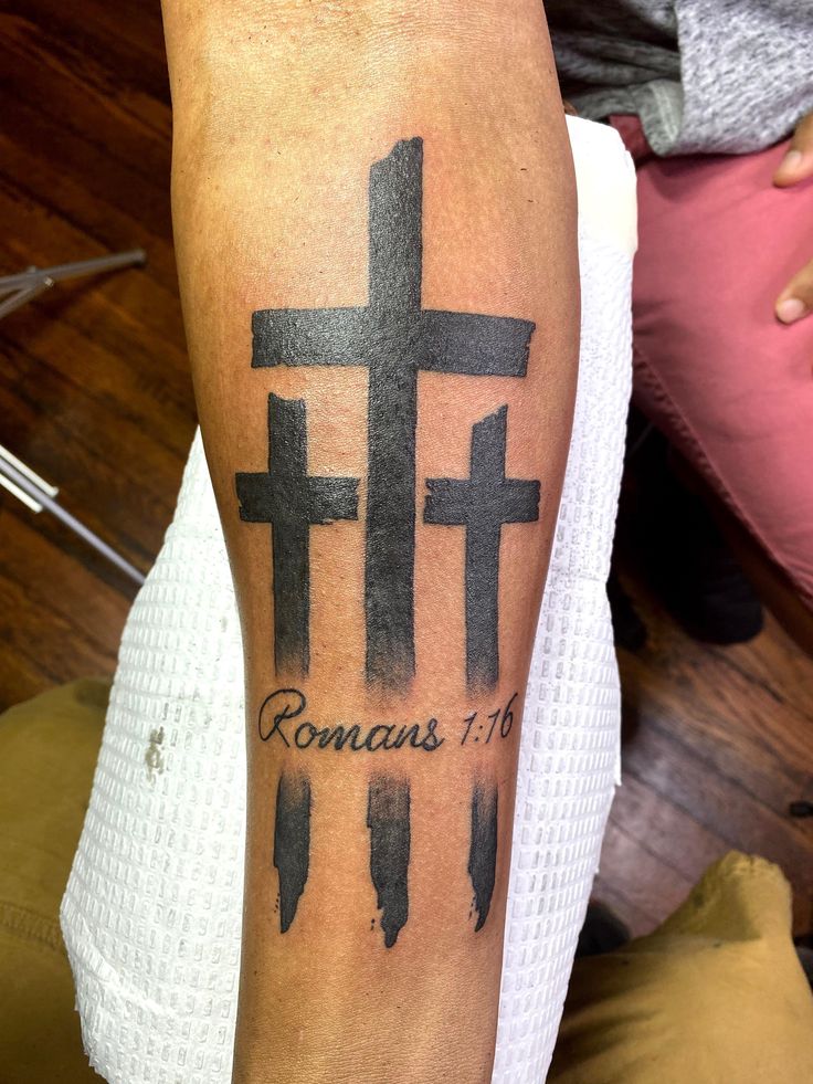 a person with a cross tattoo on their arm that says romas 17 and has arrows in it