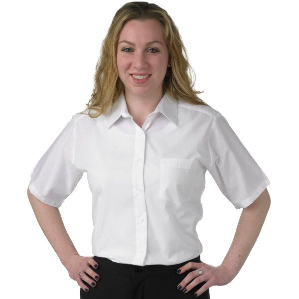 a woman standing with her hands on her hips wearing a white shirt and black pants