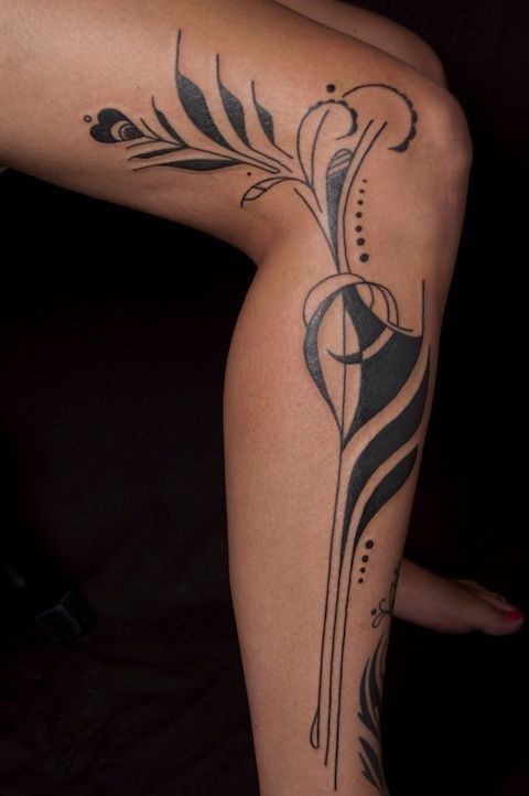 a woman's leg with tattoos on it and an arrow in the middle of her leg