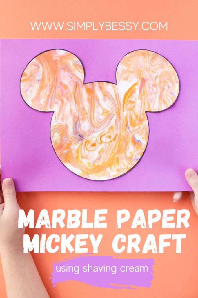 someone holding up a mickey mouse paper craft with the text, marble paper mickey craft using shaving cream