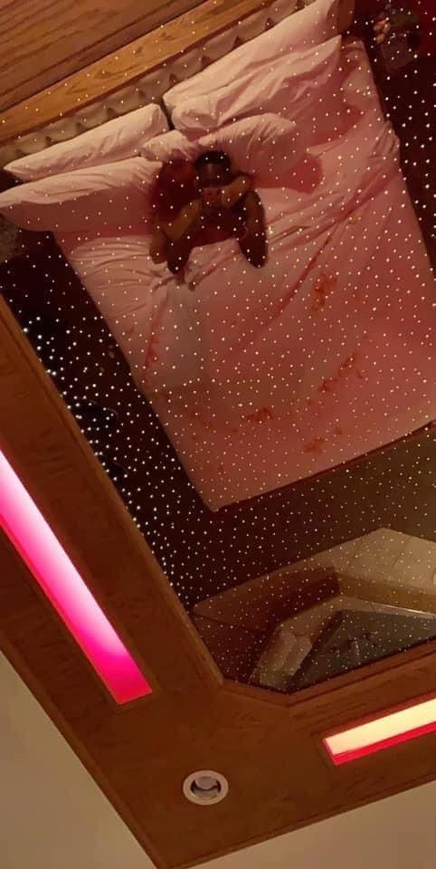 the bed is made up with pink sheets and polka dots on it, along with a teddy bear