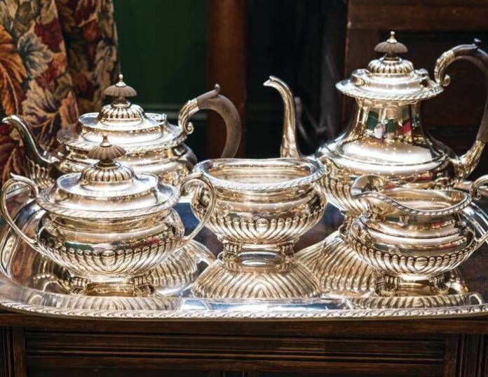 a silver tea set sitting on top of a wooden table