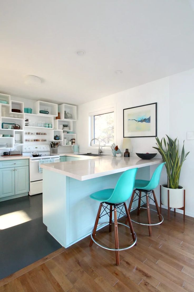 a kitchen with blue chairs and white counters