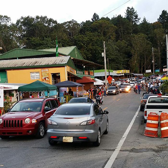 many cars are parked on the side of the road in front of shops and businesses