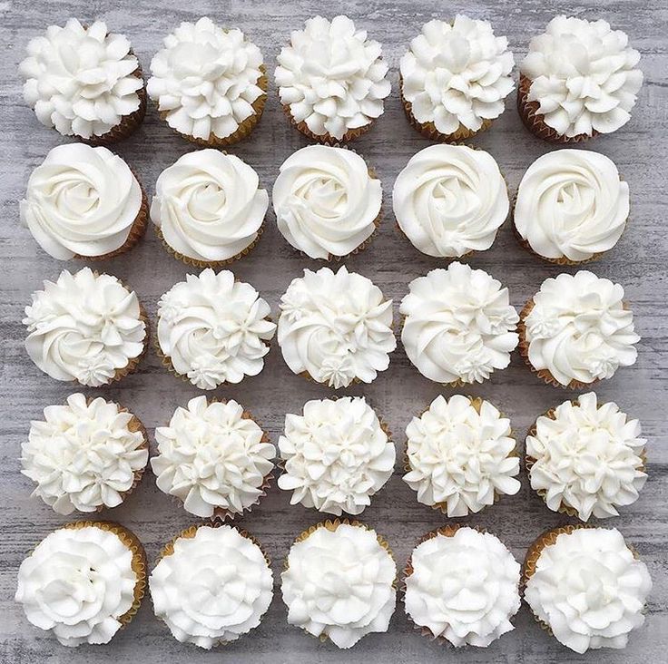 cupcakes with white frosting are arranged on a table