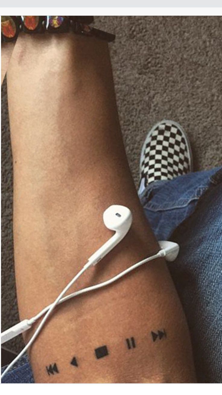 a person with a tattoo on their arm and headphones attached to the wrist that says music