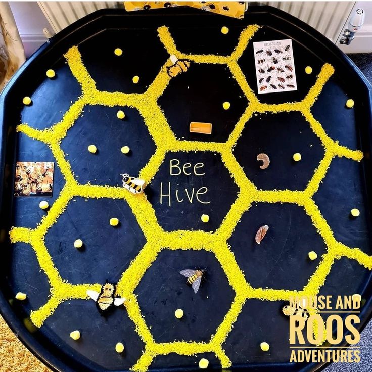 a bee hive tray with bees and honeycombs written on the side in yellow