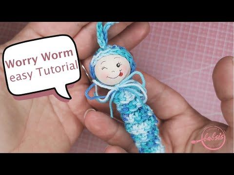 a hand holding a crocheted doll with a speech bubble saying worry worm easy