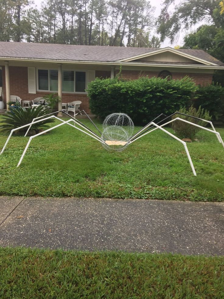 an upside down sculpture in front of a house