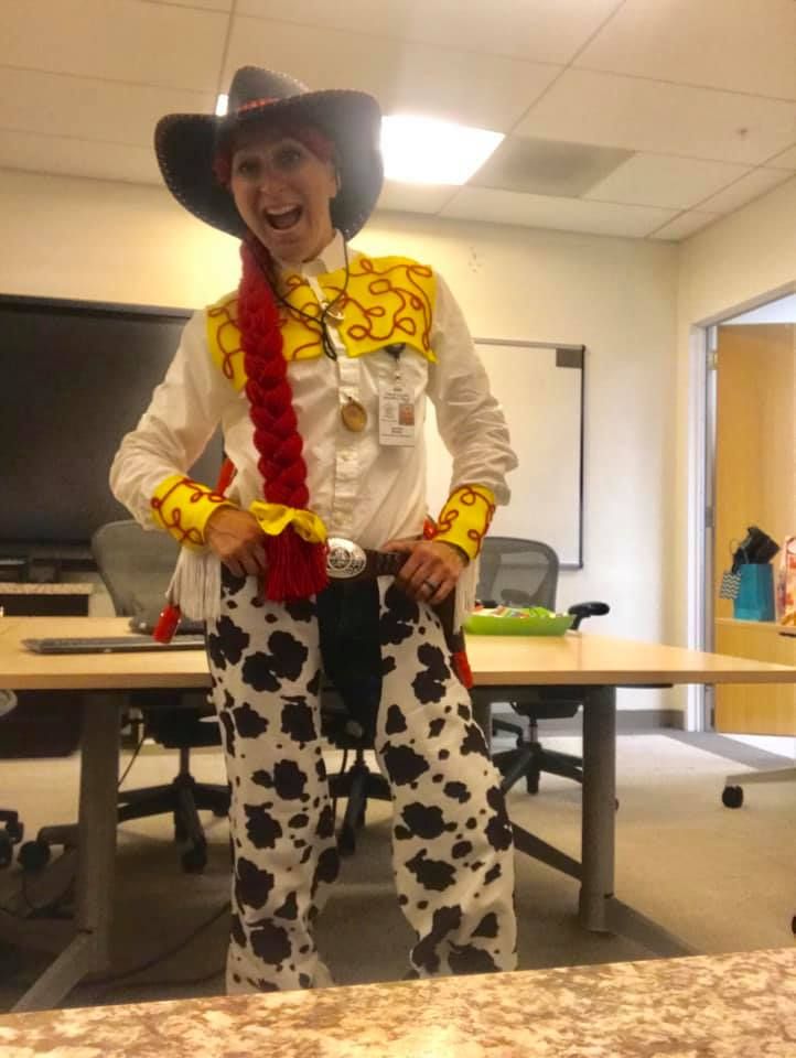 a man dressed as a cowgirl standing in an office