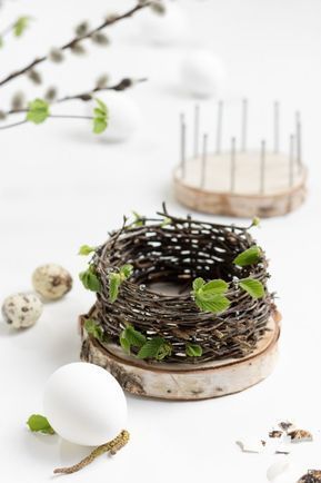 an egg is sitting in a nest next to some twigs and eggs on a white surface