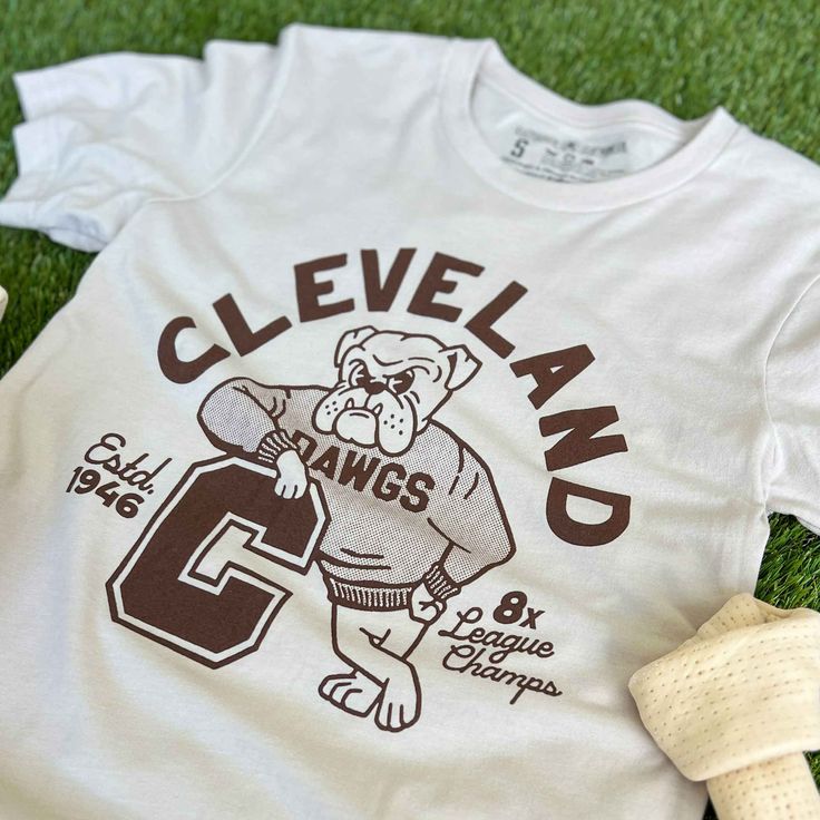 Designed and printed locally in Cleveland on a super soft heather dust unisex crewneck tee shirt with superior Airlume combed and ring-spun 100% cotton. *This product and its graphic design is not endorsed or licensed in any way by any team, or organization. SIZE BODY LENGTH CHEST WIDTH SLEEVE LENGTH CHEST TO FIT XS 27" 16.5" 8" 31"-34" S 28" 18" 8.25" 34"-37" M 29" 20" 8.625" 38"-41" L 30" 22" 9.5" 42"-45" XL 31" 24" 9.625" 46"-49" 2XL 32" 26" 10.25" 50"-53" 3XL 33" 28" 10.875" 54"-57" Retro Team Shirts, Varsity T-shirts, Vintage Sports Shirt, Sports Merch, Boy Scout Shirt, Cleveland Browns Shirts, Retro Shirt Design, Basketball Uniforms Design, Football Graphic Tee