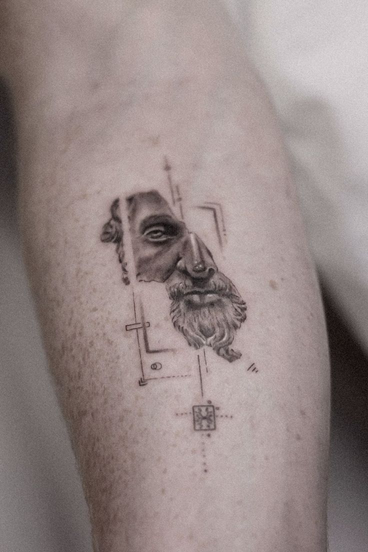 a man's leg with a portrait of a bearded man on the left calf