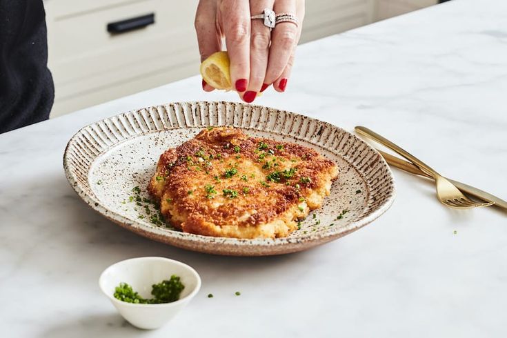 a person reaching for some food on a plate