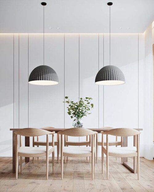 a dining room table with four chairs and a vase on the table next to it