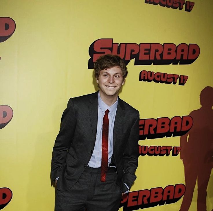 a young man in a suit and tie posing for the camera on a red carpet