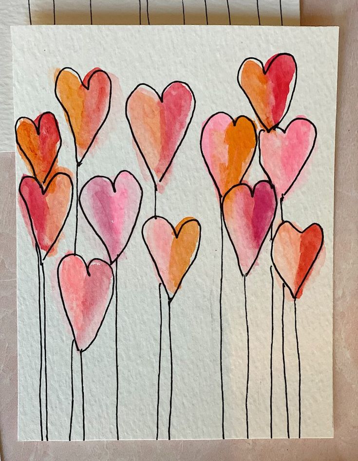 an art project with watercolors on paper and colored pencils in the shape of hearts