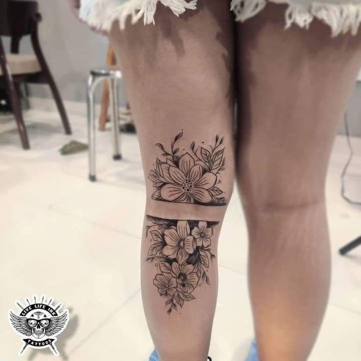 a woman's legs with flowers and a ribbon on the bottom of her leg