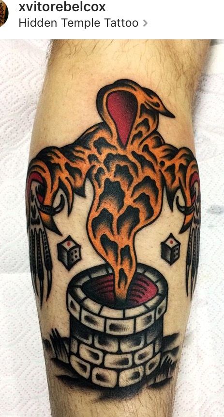 a man's arm with an orange and black tattoo design on his leg, which is