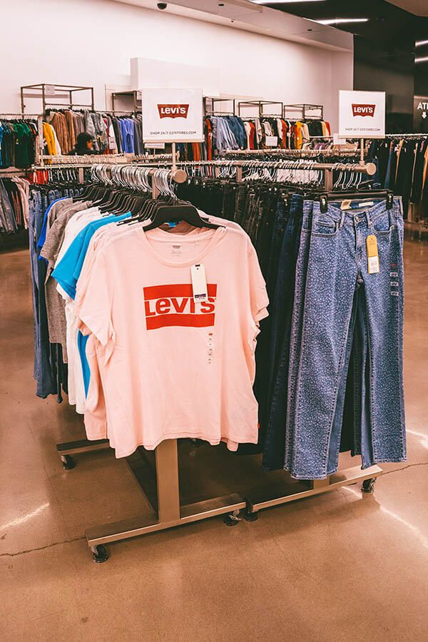 clothes on display in a clothing store with the name levi's printed on it