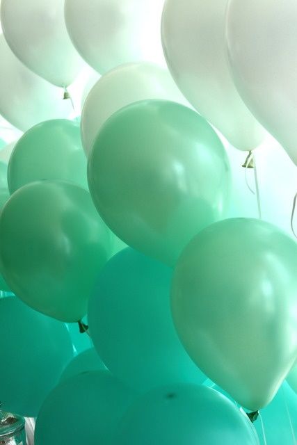 green and white balloons floating in the air