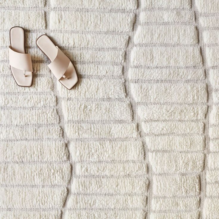 a pair of white slippers sitting on top of a bed