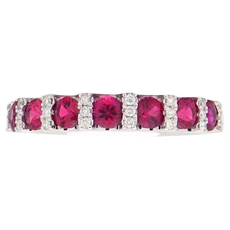 This ruby and diamond band has 7 red rubies totaling 0.87 carats which are separated by a column of SI, H color diamonds. There are 24 round diamonds totaling 0.09 carats and they are set in 2.7 grams of 14 karat white gold. This ring is size 6.5. Classic Red Ruby Ring With Single Cut Diamonds, Red Ruby Ring With Single Cut Diamonds, Ruby Ring With Pave Setting And Diamond, Red Ruby Ring With Diamond And Pave Setting, Ruby Ring With Diamond Pavé Setting, Dazzling Red Ruby Ring With Diamond Accents, Red Ruby Ring With Diamond Accents, Luxury Red Ruby Half Eternity Ring, Red Ruby Half Eternity Ring