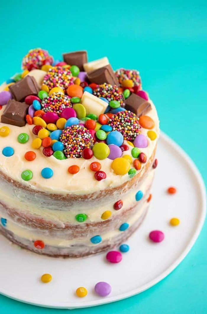 a cake with white frosting and multi colored sprinkles on the top