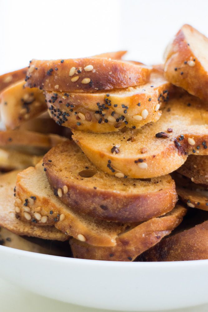 a white bowl filled with slices of bread covered in sesame seeds