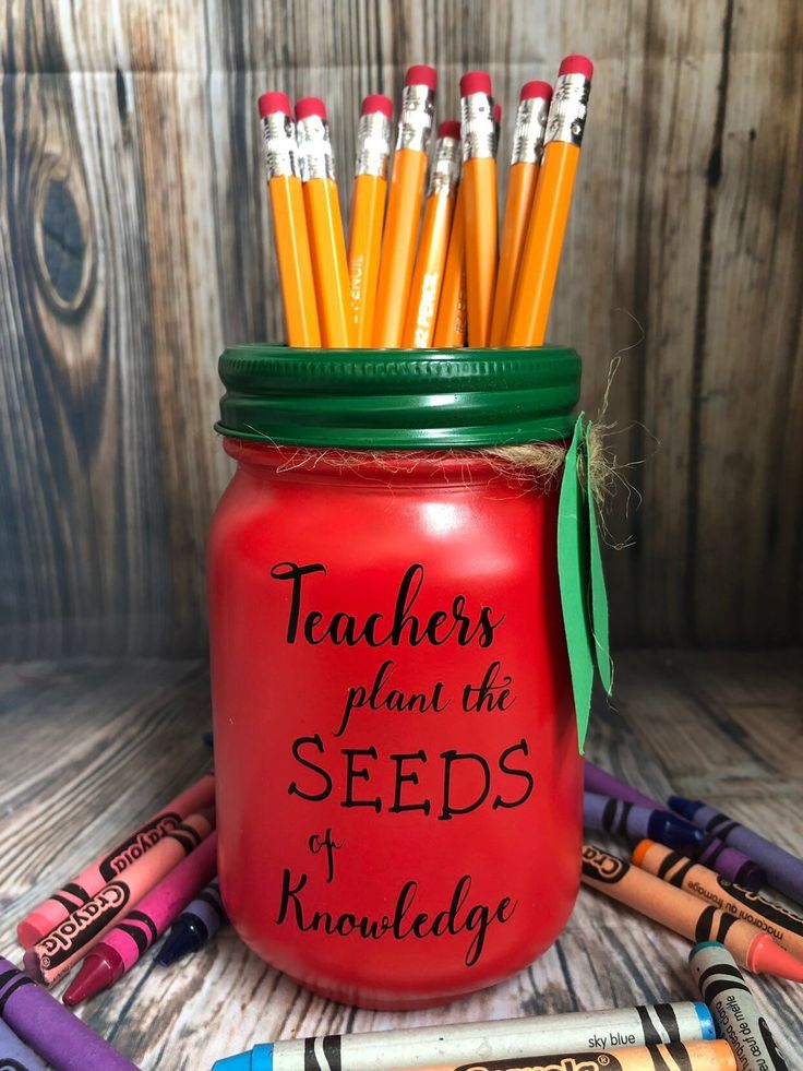 a red mason jar filled with lots of pencils