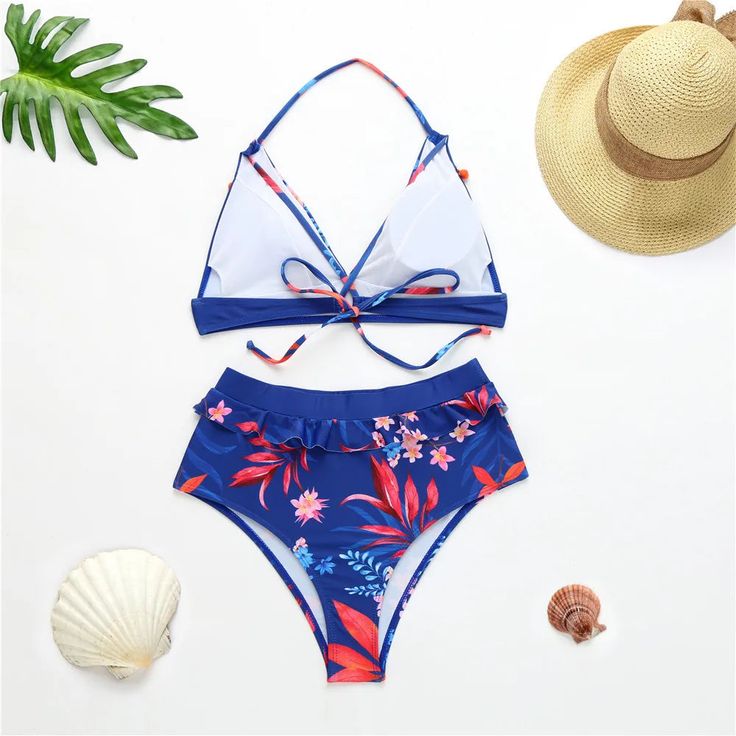 Get ready to make a splash in our Anabella Blue High Waisted Bikini! Featuring a playful tropical print and small pom pom's on the top, this bikini will have you feeling fun and flirty on your next beach day. The bottom features full coverage with added ruffle details, and we are in love with this look - and so will you! Make this stunning bikini yours and shop now! Material: Polyester and Spandex With Pad: Yes Hibiscus Print Swimwear For Beach Season, Vacation Beach Party Hibiscus Print Swimwear, Hibiscus Print Swimwear For Vacation Poolside, Hibiscus Print Swimwear For Poolside Vacation, Summer Hibiscus Print Swimwear For Pool, Tropical Hibiscus Print Swimwear For The Pool, Beachy Hibiscus Print Swimwear For Poolside, Tropical Hibiscus Print Swimwear For Pool, Hawaiian Tankini With Tropical Print