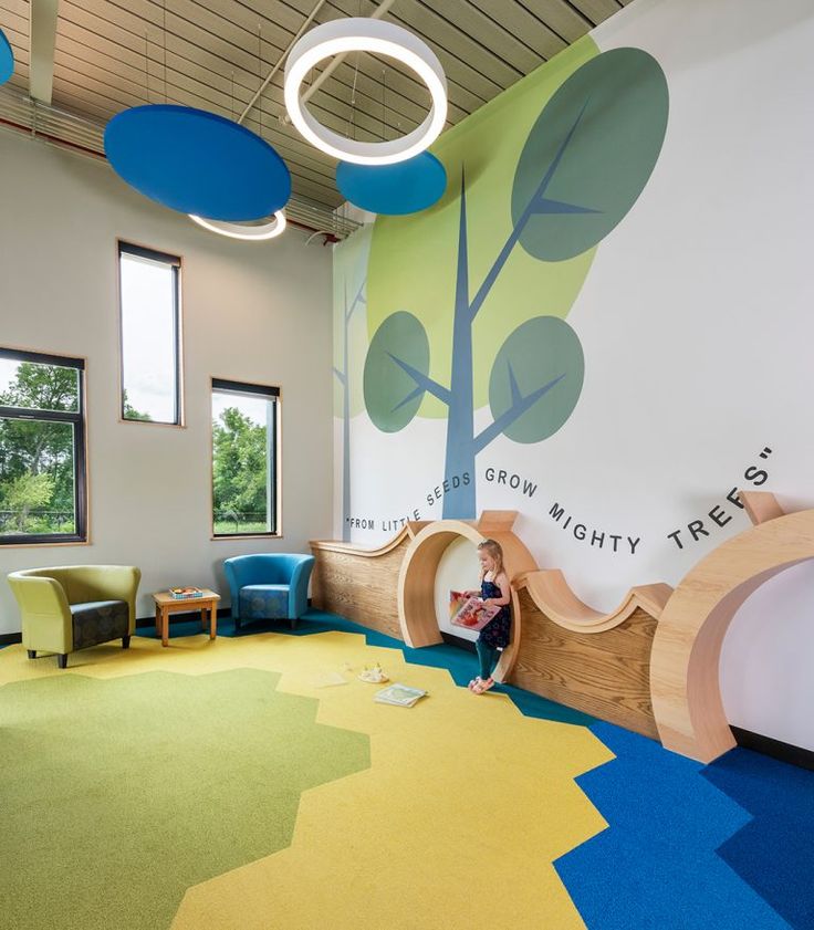 a child's playroom with colorful carpet and walls painted in blue, green, yellow and white