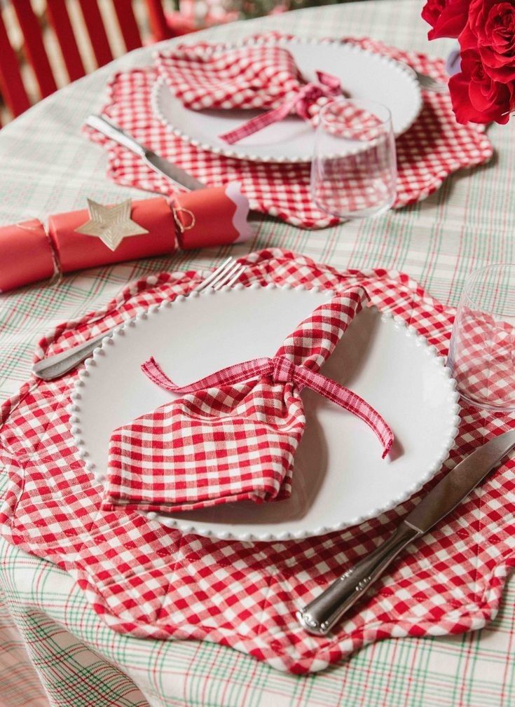 red and white checkered table cloth with napkins, silverware and rose centerpiece