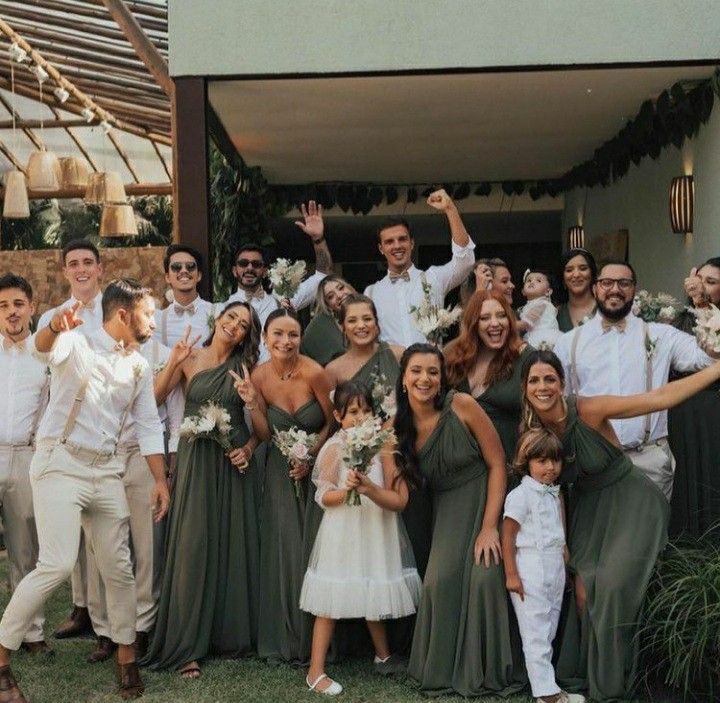 a group of people standing next to each other in front of a building with flowers